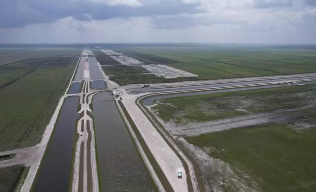 Canals run past the site, top right, where sugar cane fields are being converted into the Everglades Agricultural Area Reservoir, intended to store polluted water from Lake Okeechobee and agricultural runoff until it can be cleaned in a stormwater treatment area, bottom right, and released to flow south into the Everglades, Wednesday, May 15, 2024, in South Bay, Fla. (AP Photo/Rebecca Blackwell)