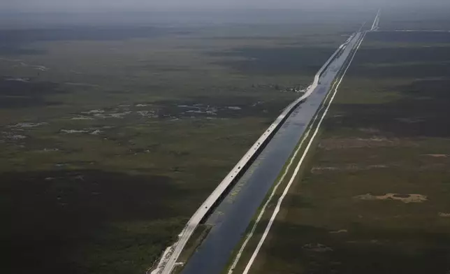 Sections of the Tamiami Trail which have been replaced with bridges to allow water to flow freely into Everglades National Park, at left, are seen from the air during a flight donated by LightHawk over the Everglades in southern Florida, Friday, May 17, 2024. (AP Photo/Rebecca Blackwell)