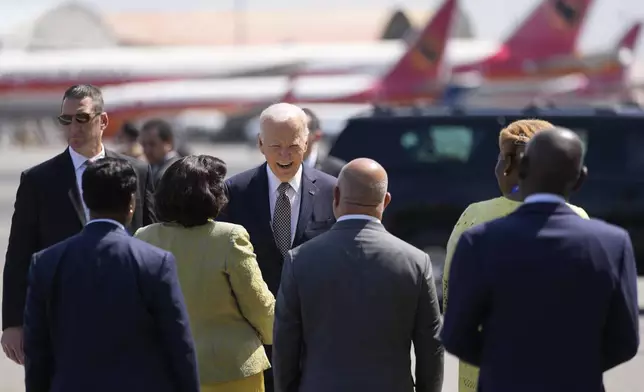 President Joe Biden talks to officials before boarding Air Force One at Quatro de Fevereiro International Airport in Luanda, Angola, on Wednesday, Dec. 4, 2024. (AP Photo/Ben Curtis)