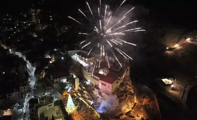 Fireworks burst over Saydnaya Convent during the lighting of the Christmas tree, in Saydnaya town on the outskirts of Damascus, Syria, Tuesday, Dec. 24, 2024. (AP Photo/Hussein Malla)