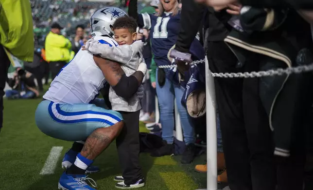 Dallas Cowboys linebacker Micah Parsons hugs his son, Malcolm, prior to an NFL football game against the Philadelphia Eagles, Sunday, Dec. 29, 2024, in Philadelphia. (AP Photo/Chris Szagola)