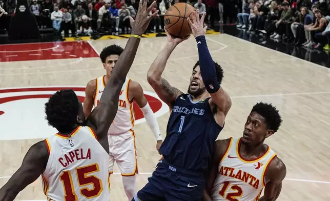 Memphis Grizzlies guard Scotty Pippen Jr. (1) shoots against Atlanta Hawks center Clint Capela (15) during the first half of an NBA basketball game, Saturday, Dec. 21, 2024, in Atlanta. (AP Photo/Mike Stewart)