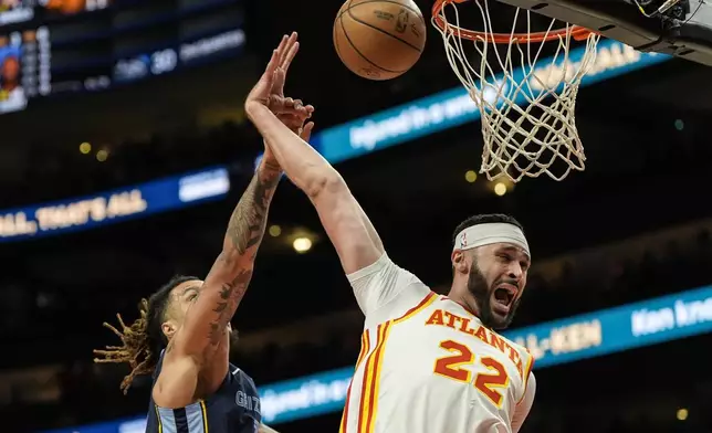 Atlanta Hawks forward Larry Nance Jr. (22) blocks a shot by Memphis Grizzlies forward Brandon Clarke (15) during the first half of an NBA basketball game, Saturday, Dec. 21, 2024, in Atlanta. (AP Photo/Mike Stewart)