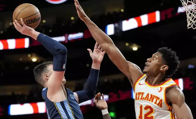 Memphis Grizzlies forward Jake LaRavia (3) shoots against Atlanta Hawks forward De'Andre Hunter (12) during the first half of an NBA basketball game, Saturday, Dec. 21, 2024, in Atlanta. (AP Photo/Mike Stewart)