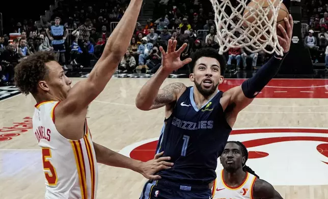 Memphis Grizzlies guard Scotty Pippen Jr. (1) shoots against Atlanta Hawks guard Dyson Daniels (5) during the first half of an NBA basketball game, Saturday, Dec. 21, 2024, in Atlanta. (AP Photo/Mike Stewart)