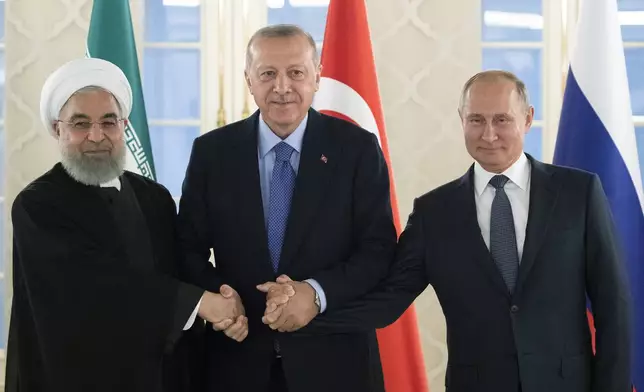 FILE - From left: Iranian President Hassan Rouhani, Turkish President Recep Tayyip Erdogan and Russian President Vladimir Putin shake hands during their meeting in Ankara, Turkey, Monday, Sept. 16, 2019. (AP Photo/Pavel Golovkin, Pool, File)