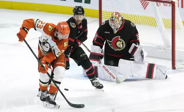 Anaheim Ducks' Mason McTavish tries to tip a shot past Ottawa Senators goaltender Linus Ullmark as he is pressured by Senators' Nick Jensen during the first period of an NHL hockey game, Wednesday, Dec. 11, 2024 in Ottawa, Ontario. (Adrian Wyld/The Canadian Press via AP)