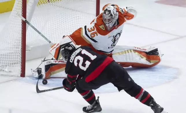 Ottawa Senators' Nick Cousins reaches for the puck as Anaheim Ducks goaltender John Gibson slides across the crease during the third period of an NHL hockey game, Wednesday, Dec. 11, 2024 in Ottawa, Ontario. (Adrian Wyld/The Canadian Press via AP)