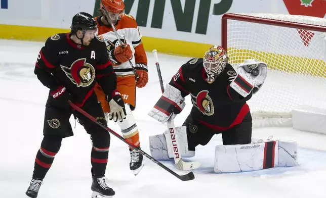 Ottawa Senators goaltender Linus Ullmark makes a glove save as Thomas Chabot, left, and Anaheim Ducks' Troy Terry look on during the first period of an NHL hockey game, Wednesday, Dec. 11, 2024 in Ottawa, Ontario. (Adrian Wyld/The Canadian Press via AP)