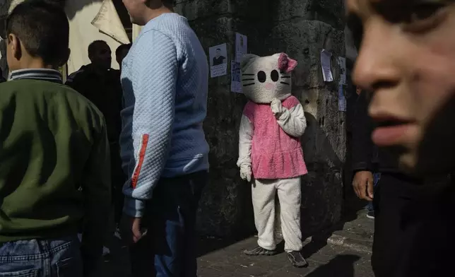 A person disguised as a cat stands in the street near the Umayyad Mosque ahead of Friday prayers in Damascus, Syria, Friday Dec. 20, 2024. 2024.(AP Photo/Leo Correa)