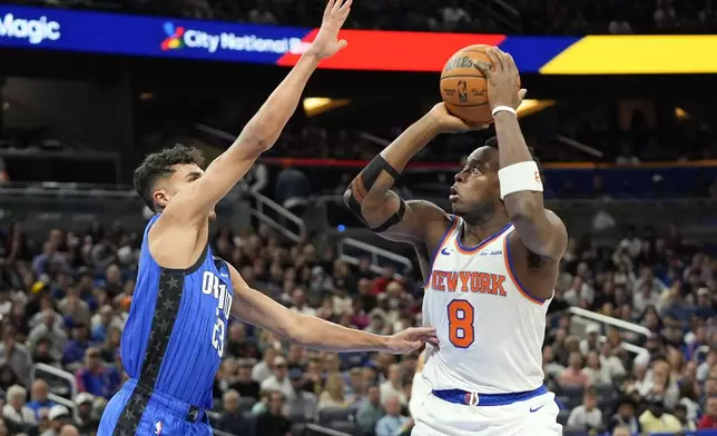 New York Knicks forward OG Anunoby (8) shoots over Orlando Magic forward Tristan da Silva, left, during the first half of an NBA basketball game, Friday, Dec. 27, 2024, in Orlando, Fla. (AP Photo/John Raoux)