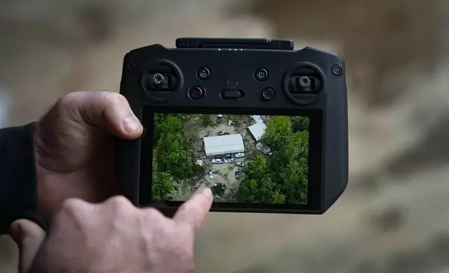 Russell Hedrick shows footage of when he used his drone to drop supplies to people during Hurricane Helene recovery, Tuesday, Dec. 17, 2024, in Hickory, N.C. (AP Photo/Allison Joyce)