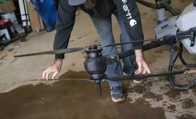 Russell Hedrick prepares a DJI drone to put crop cover on his farm, Tuesday, Dec. 17, 2024, in Hickory, N.C. (AP Photo/Allison Joyce)