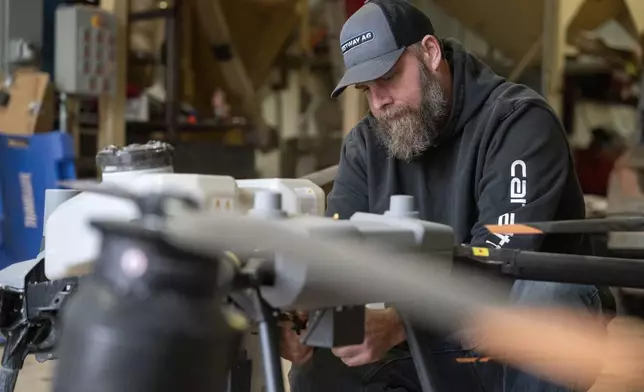 Russell Hedrick prepares a DJI drone to put crop cover on his farm, Tuesday, Dec. 17, 2024, in Hickory, N.C. (AP Photo/Allison Joyce)