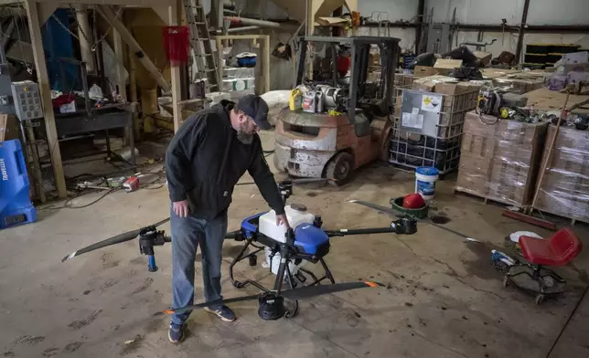 Russell Hedrick pulls out an EA Vision drone on his farm, Tuesday, Dec. 17, 2024, in Hickory, N.C. (AP Photo/Allison Joyce)