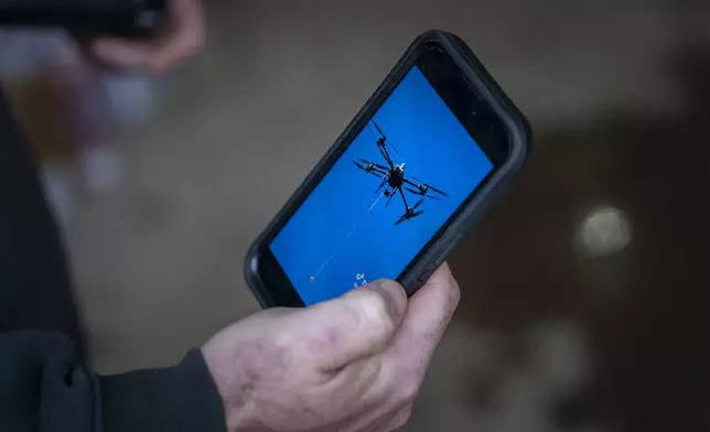 Russell Hedrick shows footage of when he used his drone to drop supplies to people during Hurricane Helene recovery, Tuesday, Dec. 17, 2024, in Hickory, N.C. (AP Photo/Allison Joyce)