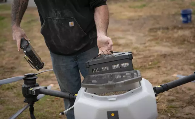 Russell Hedrick puts a battery in a DJI drone to put crop cover on his farm, Tuesday, Dec. 17, 2024, in Hickory, N.C. (AP Photo/Allison Joyce)