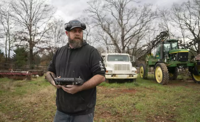 Russell Hedrick uses a DJI drone to put crop cover on his farm, Tuesday, Dec. 17, 2024, in Hickory, N.C. (AP Photo/Allison Joyce)