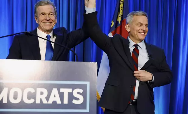 FILE - North Carolina's Democratic gubernatorial candidate Josh Stein, right, is introduced by North Carolina Gov. Roy Cooper at a primary election night party in Raleigh, N.C., March 5, 2024. (AP Photo/Karl B DeBlaker, File)