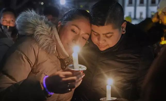 Supporters hold candles during a candlelight vigil Tuesday, Dec. 17, 2024, outside the Wisconsin Capitol in Madison, Wis., following a shooting at the Abundant Life Christian School on Monday, Dec. 16. (AP Photo/Morry Gash)