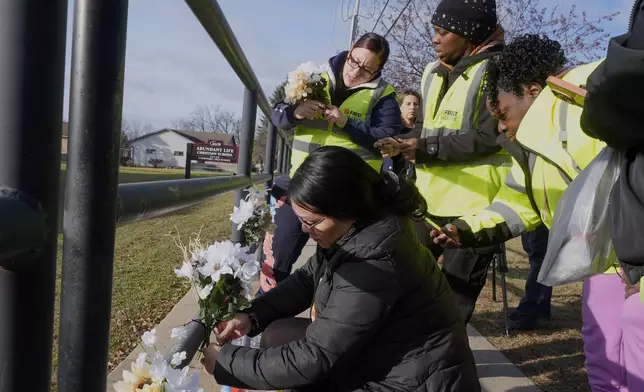 People put flowers outside the Abundant Life Christian School Tuesday, Dec. 17, 2024 in Madison, Wis., following a shooting on Monday. (AP Photo/Morry Gash)