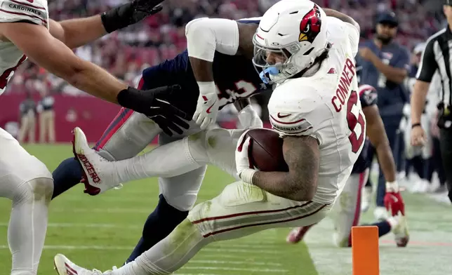 New England Patriots cornerback Jonathan Jones tackles Arizona Cardinals running back James Conner (6) during the second half of an NFL football game, Sunday, Dec. 15, 2024, in Glendale, Ariz. (AP Photo/Rick Scuteri)