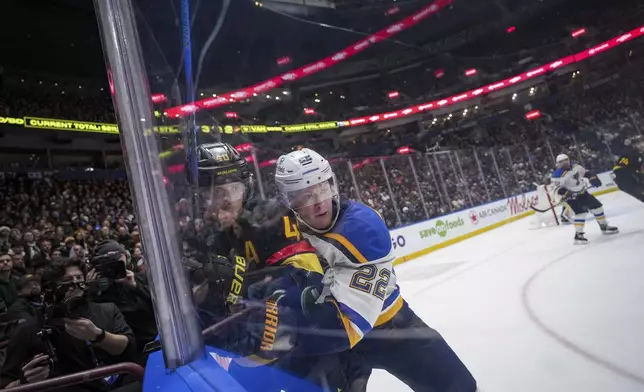 St. Louis Blues' Ryan Suter (22) checks Vancouver Canucks' Elias Pettersson (40) during the third period of of an NHL hockey game in Vancouver Tuesday, Dec. 10, 2024. (Darryl Dyck/The Canadian Press via AP)