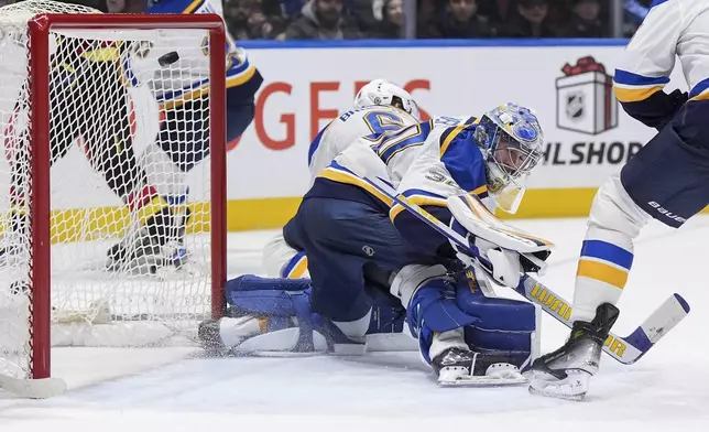 St. Louis Blues goalie Joel Hofer (30) allows a goal to Vancouver Canucks' Jake DeBrusk, not seen, during the third period of an NHL hockey game in Vancouver Tuesday, Dec. 10, 2024. (Darryl Dyck/The Canadian Press via AP)