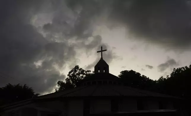 Storm clouds loom over the San Isidro Labrador church in Tocoa, Honduras, Friday, Dec. 6, 2024. (AP Photo/Moises Castillo)