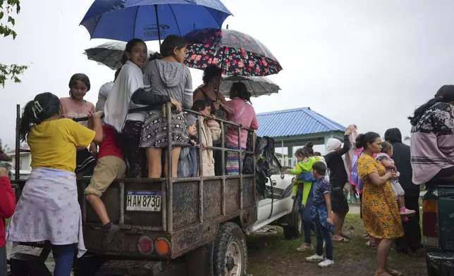 Residents board a vehicle after attending a burial service at a cemetery in Tocoa, Honduras, Saturday, Dec. 7, 2024. (AP Photo/Moises Castillo)