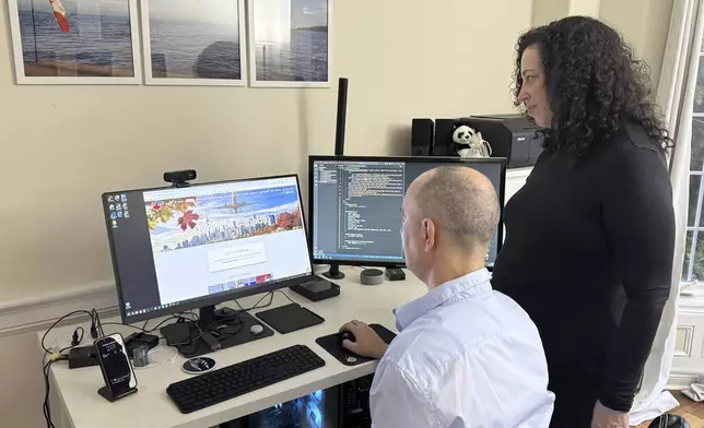 Michal Harel and her husband Avital Epstein show the website they set up to help Israelis navigate a move to Canada in Oakville, Ontario, Canada, Wednesday, Dec. 4, 2024. (AP Photo/Rob Gillies)