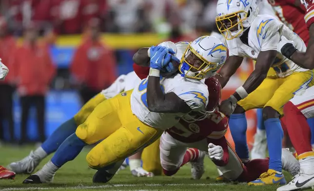 Los Angeles Chargers running back Kimani Vidal (30) struggles for yardage during the second half of an NFL football game against the Kansas City Chiefs Sunday, Dec. 8, 2024, in Kansas City, Mo. (AP Photo/Charlie Riedel)