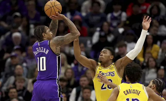 Sacramento Kings forward DeMar DeRozan (10) shoots against Los Angeles Lakers forward Rui Hachimura (28) during the first half of an NBA basketball game in Sacramento, Calif., Thursday, Dec. 19, 2024. (AP Photo/Jed Jacobsohn)