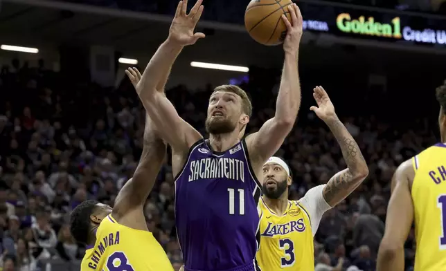 Sacramento Kings center Domantas Sabonis (11) shoots against Los Angeles Lakers forward Rui Hachimura (28) during the second half of an NBA basketball game in Sacramento, Calif., Thursday, Dec. 19, 2024. (AP Photo/Jed Jacobsohn)