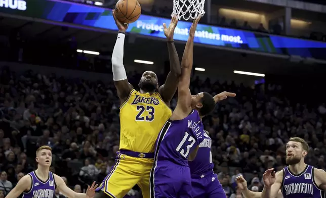 Los Angeles Lakers forward LeBron James (23) shoots against Sacramento Kings forward Keegan Murray (13) during the first half of an NBA basketball game in Sacramento, Calif., Thursday, Dec. 19, 2024. (AP Photo/Jed Jacobsohn)