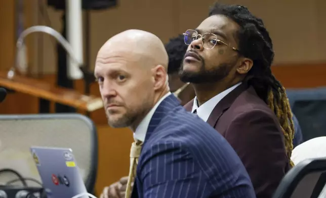 Shannon Stillwell, center back, sits with his attorney, Max Schardt, left, as he looks at the prosecutors during the Young Thug trial at Fulton County Courthouse in Atlanta on Tuesday, Nov. 26, 2024. (Miguel Martinez/Atlanta Journal-Constitution via AP)