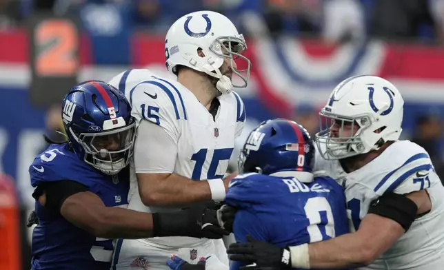 New York Giants defenders sack Indianapolis Colts quarterback Joe Flacco (15) and cause a fumble to end the Colts' final drive in the fourth quarter of an NFL football game Sunday, Dec. 29, 2024, in East Rutherford, N.J. (AP Photo/Seth Wenig)