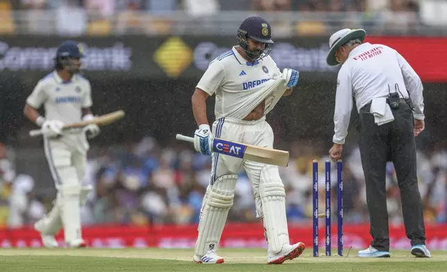 India's captain Rohit Sharma, center, and his batting partner KL Rahul leaves the field as rain stops play during play on day three of the third cricket test between India and Australia at the Gabba in Brisbane, Australia, Monday, Dec. 16, 2024. (AP Photo/Pat Hoelscher)