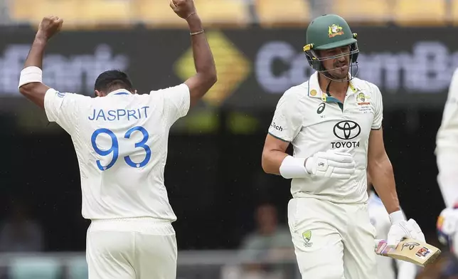 India's Jasprit Bumrah, left, celebrates after dismissing Australia's Mitchell Starc, right, during play on day three of the third cricket test between India and Australia at the Gabba in Brisbane, Australia, Monday, Dec. 16, 2024. (AP Photo/Pat Hoelscher)