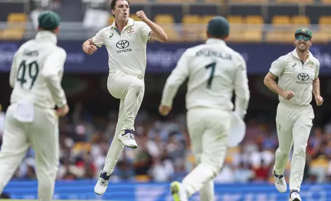 Australia's captain Pat Cummins, second left, celebrates with teammates after the dismissal of India's Rishabh Pant during play on day three of the third cricket test between India and Australia at the Gabba in Brisbane, Australia, Monday, Dec. 16, 2024. (AP Photo/Pat Hoelscher)