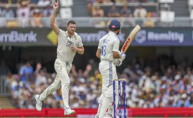 Australia's Josh Hazlewood, left, celebrates the wicket of India's Virat Kohli, right, during play on day three of the third cricket test between India and Australia at the Gabba in Brisbane, Australia, Monday, Dec. 16, 2024. (AP Photo/Pat Hoelscher)