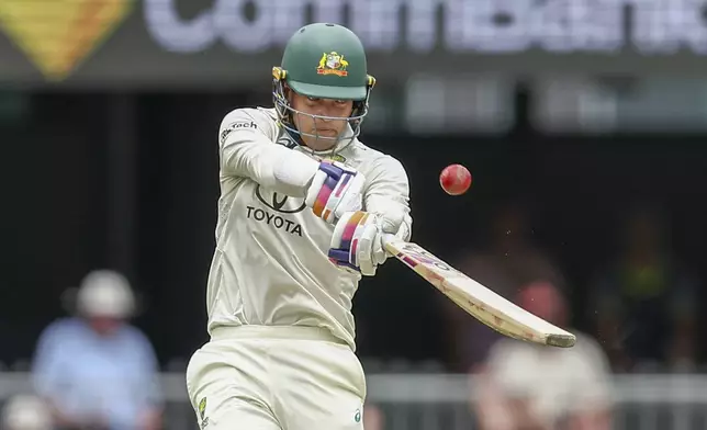 Australia's Alex Carey hits the ball in the air before being caught out by India's Shubman Gill during play on day three of the third cricket test between India and Australia at the Gabba in Brisbane, Australia, Monday, Dec. 16, 2024. (AP Photo/Pat Hoelscher)