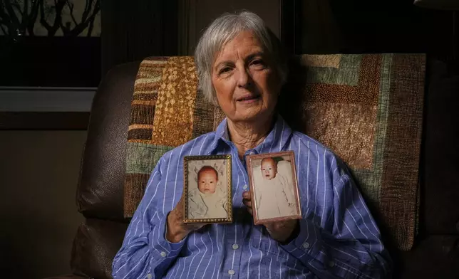 Peg Reif holds pictures of her children adopted from South Korea in the 1980s in her home Tuesday, Dec. 17, 2024 in Platteville, Wis. (AP Photo/Morry Gash)