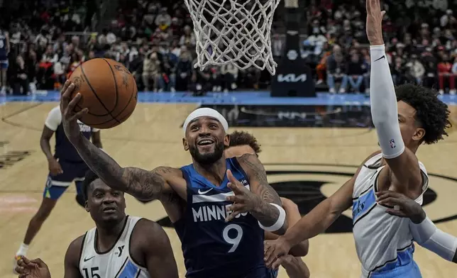 Minnesota Timberwolves guard Nickeil Alexander-Walker (9) shoots against Atlanta Hawks center Clint Capela (15) during the first half of an NBA basketball game, Monday, Dec. 23, 2024, in Atlanta. (AP Photo/Mike Stewart)