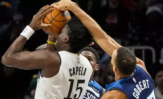 Atlanta Hawks center Clint Capela (15) shoots against Minnesota Timberwolves center Rudy Gobert (27) during the first half of an NBA basketball game, Monday, Dec. 23, 2024, in Atlanta. (AP Photo/Mike Stewart)