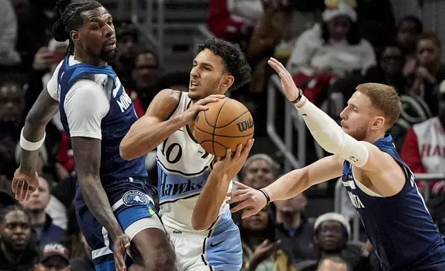 Atlanta Hawks forward Zaccharie Risacher (10) passes the ball against against the Minnesota Timberwolves during the first half of an NBA basketball game, Monday, Dec. 23, 2024, in Atlanta. (AP Photo/Mike Stewart)