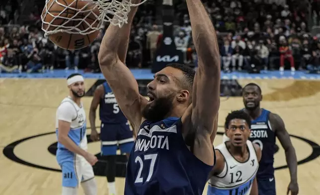 Minnesota Timberwolves center Rudy Gobert (27) dunks against the Atlanta Hawks during the first half of an NBA basketball game, Monday, Dec. 23, 2024, in Atlanta. (AP Photo/Mike Stewart)