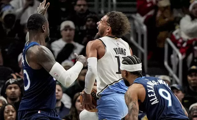 Atlanta Hawks guard Trae Young (11) drives against Minnesota Timberwolves forward Julius Randle (30) during the first half of an NBA basketball game, Monday, Dec. 23, 2024, in Atlanta. (AP Photo/Mike Stewart)