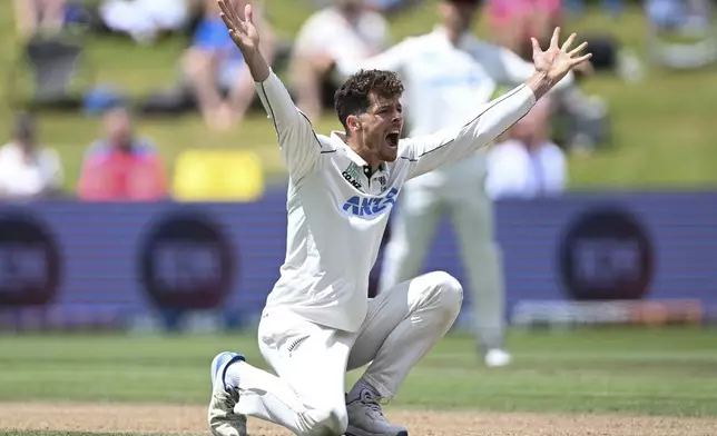 New Zealand's Mitchell Santner appeals successfully for a LBW decision to dismiss England's Joe Root during play on day four of the third cricket test between England and New Zealand in Hamilton, New Zealand, Tuesday, Dec. 17, 2024. (Andrew Cornaga/Photosport via AP)