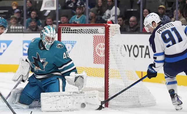 San Jose Sharks goaltender Alexandar Georgiev (40) blocks a goal attempt by Winnipeg Jets center Cole Perfetti (91) during the second period of an NHL hockey game in San Jose, Calif., Tuesday, Dec. 17, 2024. (AP Photo/Tony Avelar)